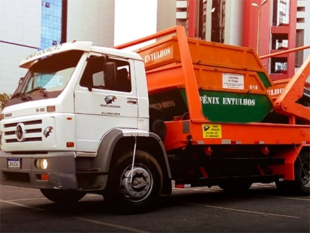 imagem do caminhão carregando caçambas da fênix locações