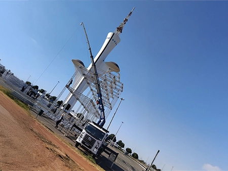imagem de um caminhão munck ajudando na montagem de estruturas metálicas